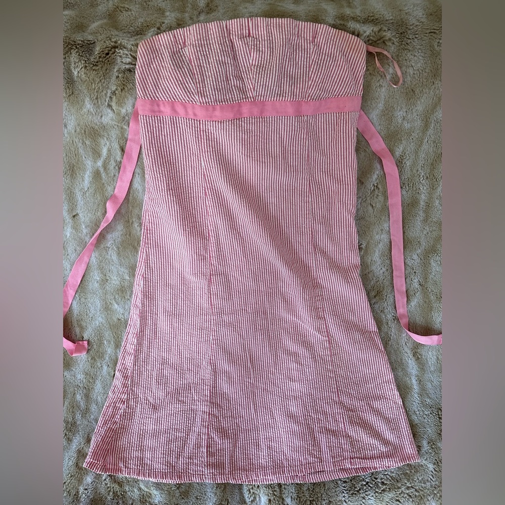 White/pink seersucker strapless dress with tie back detail and back zipper.